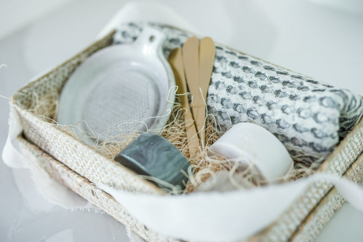 Mercy Forest Co. client gift box, perfect for real estate advisors to share with clients, presented in a woven seagrass box with a lid. Inside, the gift set includes three marble dishes in white, tan, and charcoal with brass spreading knives, a stoneware grater, and a cotton waffle weave kitchen tea towel—an elegant and memorable way to celebrate client relationships and express appreciation.