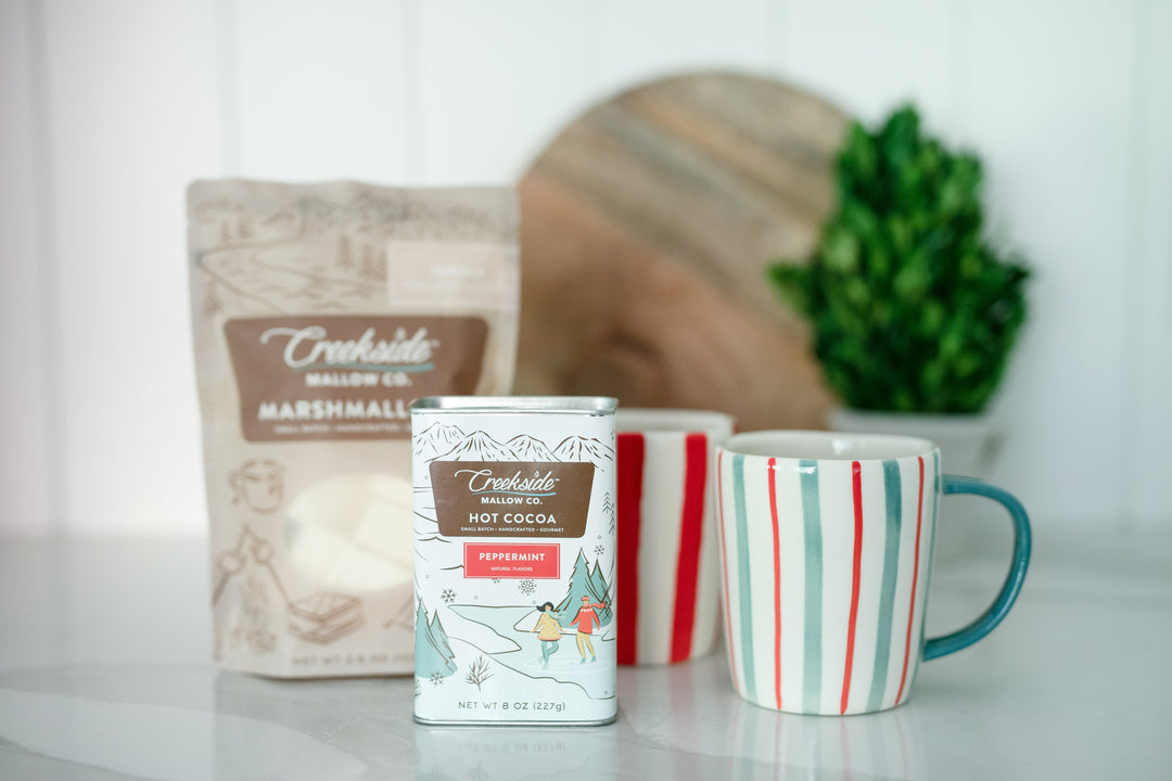 White kitchen with Peppermint hot chocolate, striped stoneware mugs, and vanilla marshmallows. 