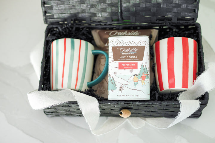 Mercy Forest Co. Gifting Service helps real estate advisors gift intentionally and in the moment with this hot chocolate themed gift box called CoCo. Gift comes in a black woven box with hinge top and includes peppermint hot coco, gourmet vanilla marshmallows, and two stoneware striped mugs. Local pick up available in Independence MN. 