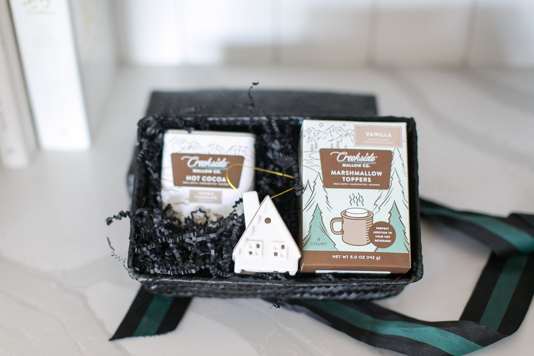 Marshmallow toppers packaging with a small house-shaped LED ceramic ornament on a blurred background