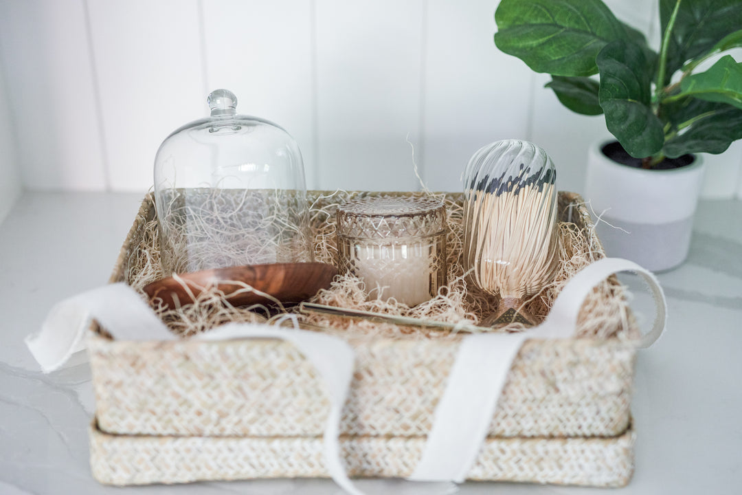 Mercy Forest Co. gift box ready to ship with reusable woven box, glass cloche with wood base, oak & ember glass jar candle, skeem match jar, brass wick snip, and brass candle snuffer. 