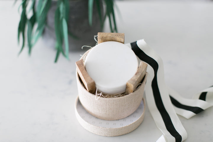 A gift box including marble coasters in a wooden coaster holder. 