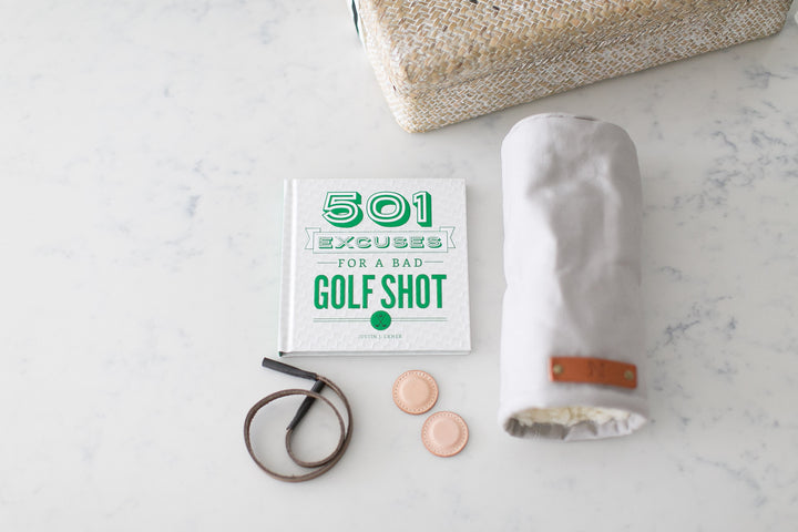 Golf enthusiests gift box that includes Golf excuses hardcover book, leather sunglass strap, leather ball markers, and canvas golf club head cover. 