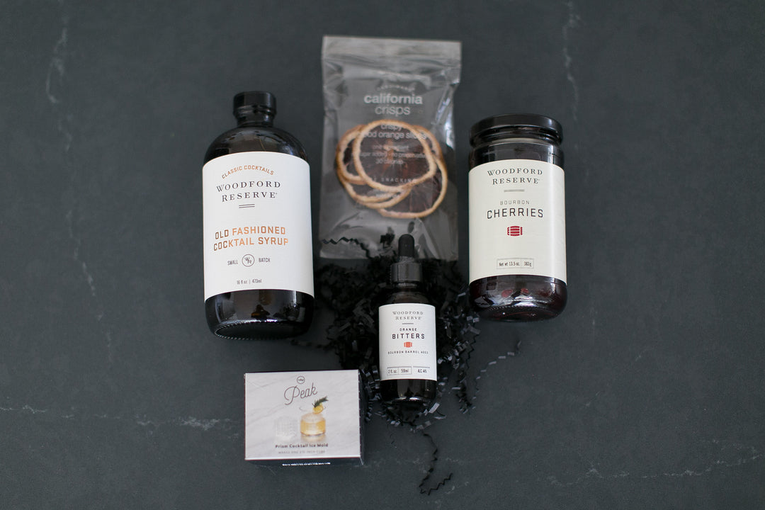Collection of Woodford Reserve cocktail ingredients on a dark surface