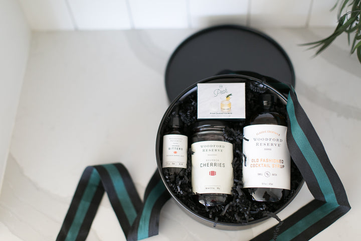 Three bottles of Godiva chocolate liqueur in a black gift box with a ribbon on a white background.