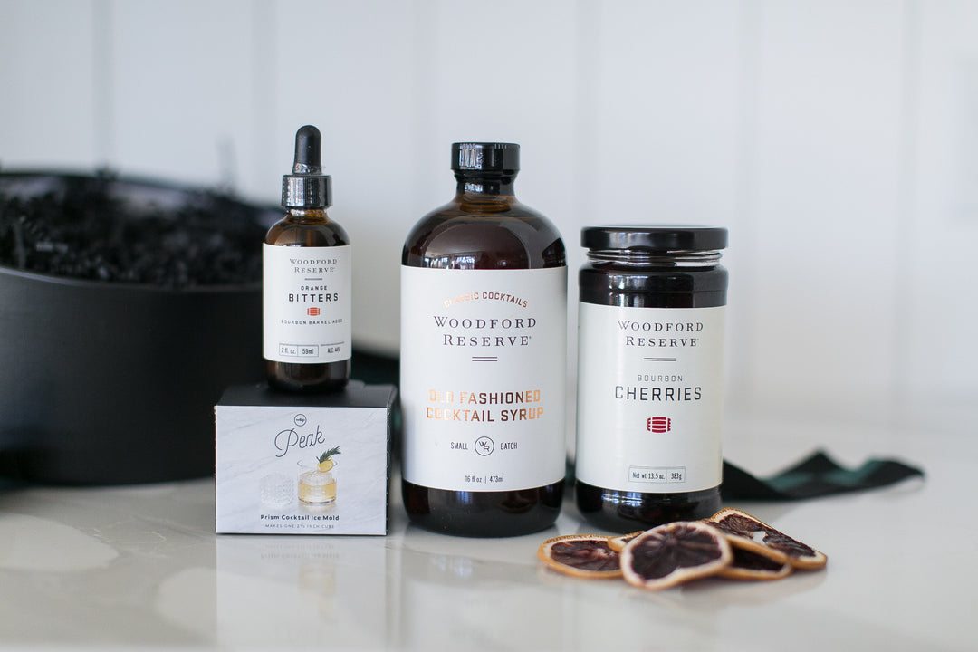 Collection of Woodford Reserve bitters, syrups, and cherries on a countertop.