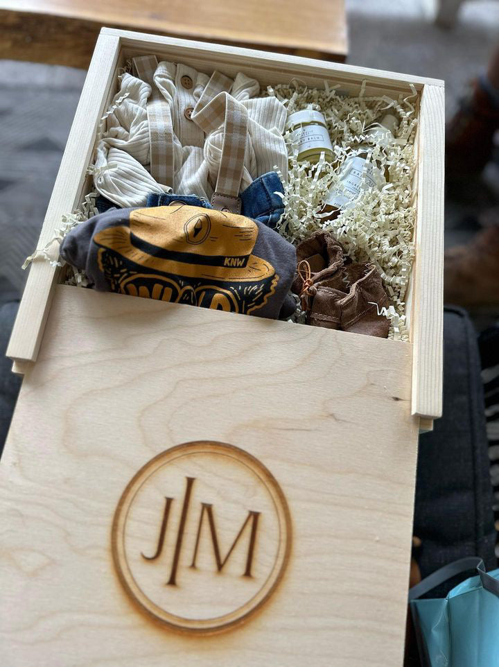A wooden box with clothes, shoes and other oils inside.