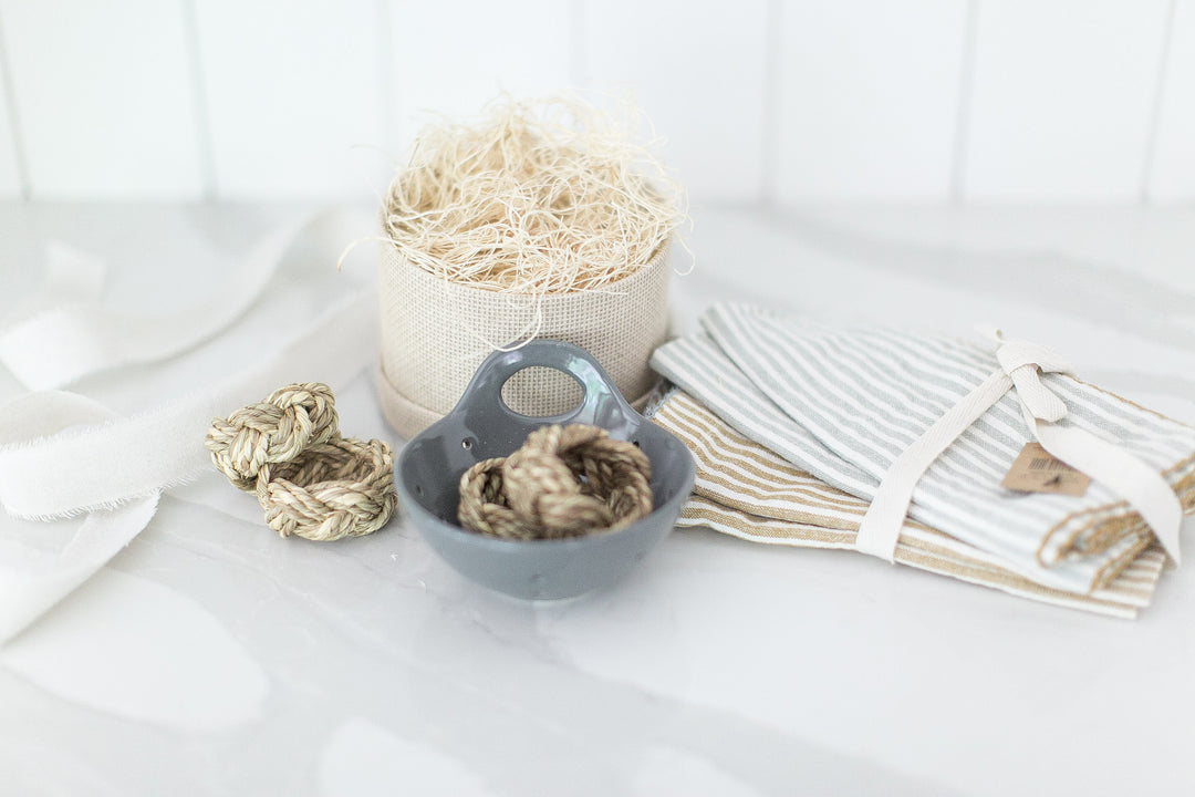 Mercy Forest Co. ready to ship gift box with stoneware berry bowl, scalloped cloth napkins and braided seagrass napkin rings. Ships in a woven paper gift box. Reusable and Sustainable.