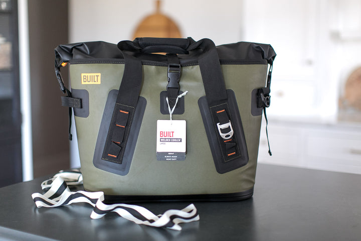 Green and black cooler bag with visible branding on a table