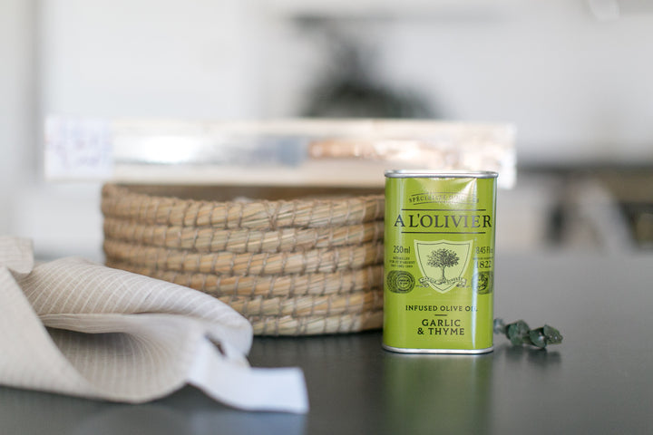 Green canister labeled 'Al Oliver' on a kitchen counter with a blurred background