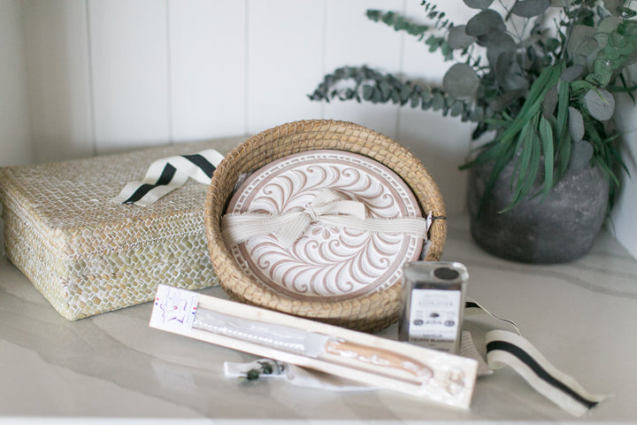 Decorative items including a woven basket, box, and small plant on a light surface.