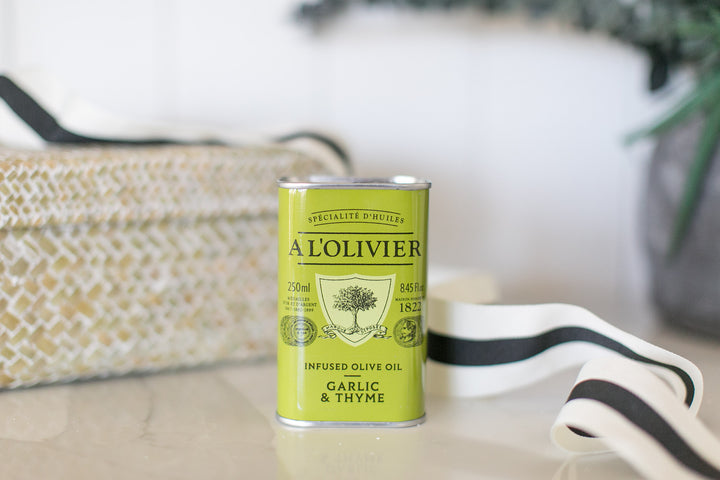 Can of A'L Olivier infused olive oil with garlic and thyme on a surface.