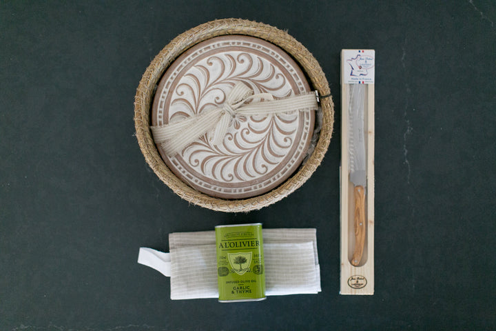 Wooden stamp with intricate design, a knife, a soap bar, and a box on a dark surface